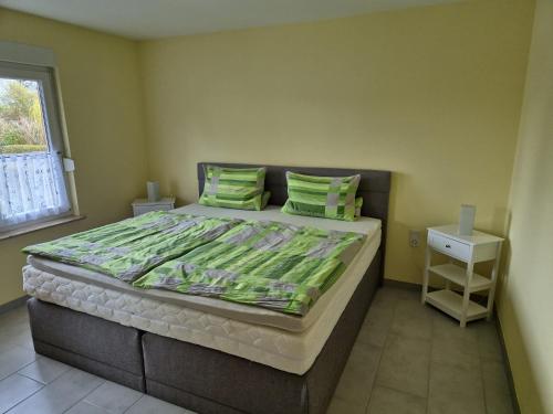 a bedroom with a large bed with green pillows at Ferienhaus Siggi in Walow