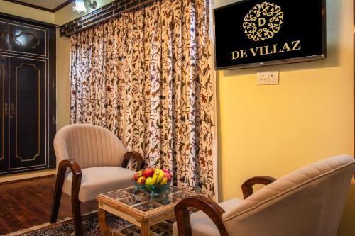 salon z 2 krzesłami i stołem z napisem w obiekcie De-Villaz w mieście Śrinagar