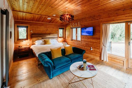 1 dormitorio con cama, sofá y mesa en Bazare Lodge en Great Ayton