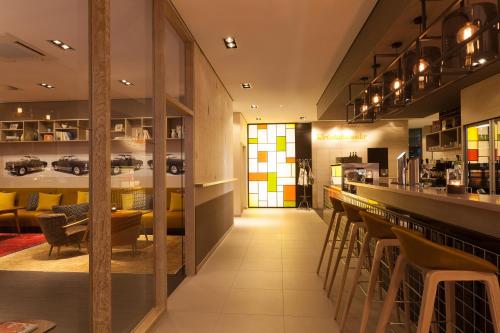 a restaurant with a bar with chairs and tables at Vienna House Easy by Wyndham Osnabrück City & Apartments in Osnabrück