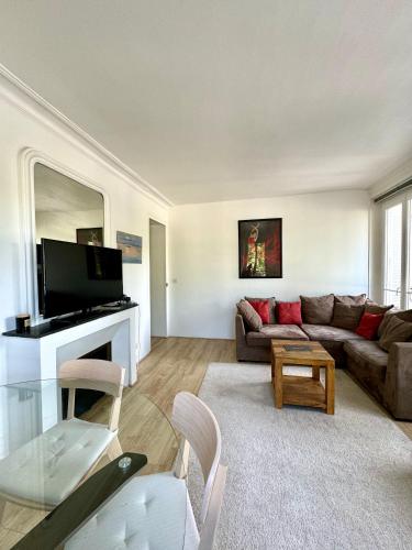 un salon avec un canapé et une cheminée dans l'établissement Très bel appartement 3 pièces à Paris Centre, à Paris