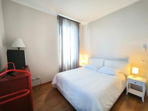 - une chambre avec un lit blanc et une fenêtre dans l'établissement LA CASA GIALLA, à Baveno