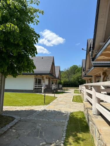 a house with a fence next to a driveway at Bieszczadzka Dziupla in Cisna