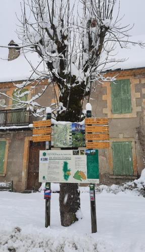 a sign in the snow in front of a tree at Les Vagabonds du Mont in Chichilianne