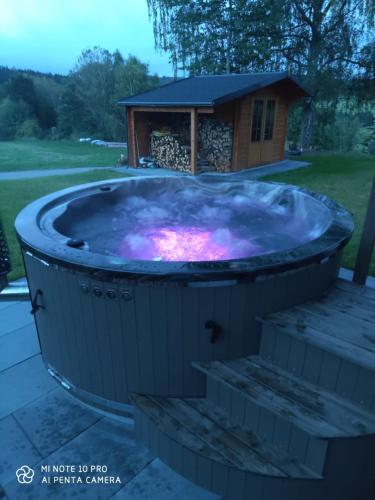 a jacuzzi tub in front of a house at Landhaus Rachelblick in Eppenschlag