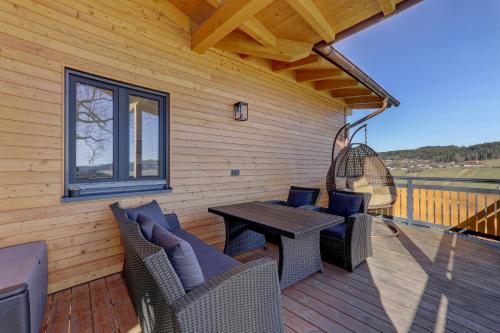 a patio with a table and chairs on a deck at Landhaus Rachelblick in Eppenschlag