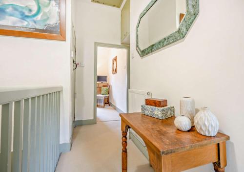 a hallway with a table with vases on it at Honey Hill House in Docking