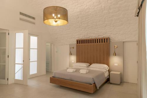a bedroom with a large bed and a light at Palazzo AD 1892 - SUITES & SPA in Ostuni