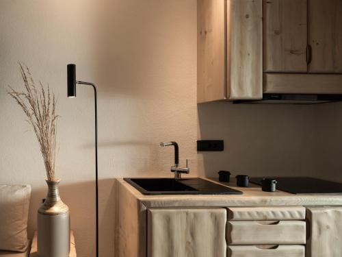 a kitchen with a sink and a vase on the floor at Manili Boutique Suites & Villas in Archanes