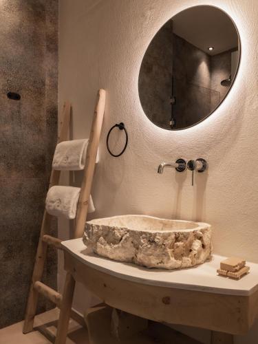 a bathroom with a stone sink and a mirror at Manili Boutique Suites & Villas in Archanes
