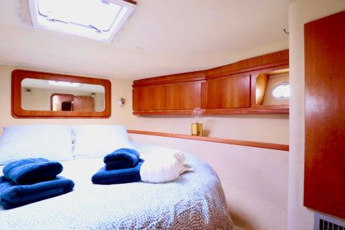 Un dormitorio con una cama con toallas azules. en YACHT DEAUVILLE, en Deauville