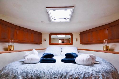 une chambre avec un lit avec des oreillers dessus dans l'établissement YACHT DEAUVILLE, à Deauville