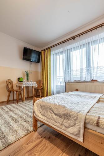 a bedroom with a large bed and a large window at Dworek pod Tatrami in Ząb