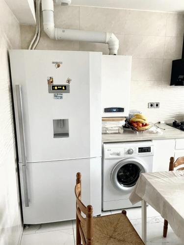 une cuisine avec un réfrigérateur et une machine à laver dans l'établissement Villa charmante à Élancourt avec jardin privé, à Élancourt