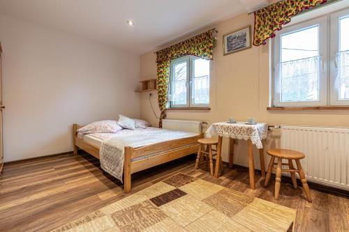 a bedroom with a bed and a table and chairs at Dworek pod Tatrami in Ząb