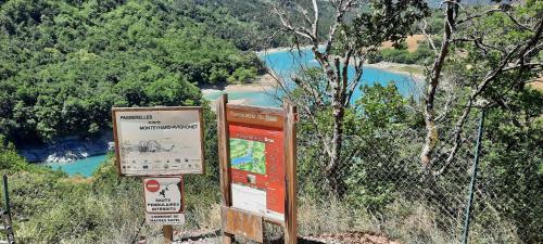 two signs on the side of a hill overlooking a river at Les Vagabonds du Mont in Chichilianne