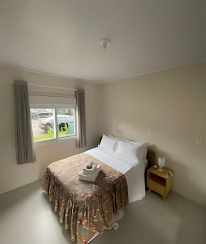 新彼得羅波利斯的住宿－Recanto Sossego，一间卧室设有一张大床和窗户