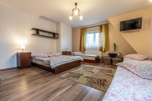a room with three beds and a tv at Dworek pod Tatrami in Ząb