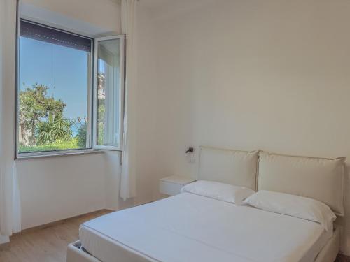 a white couch in a room with a window at Casa Acquachiara - a due passi dalla spiaggia in Monte Argentario