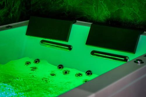 d'une baignoire avec des lumières vertes. dans l'établissement *Love Room : *Pour un séjour en amoureux*, à Sotteville-lès-Rouen