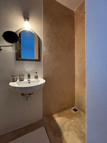 a bathroom with a sink and a mirror at Dar Lalzohra in Rabat