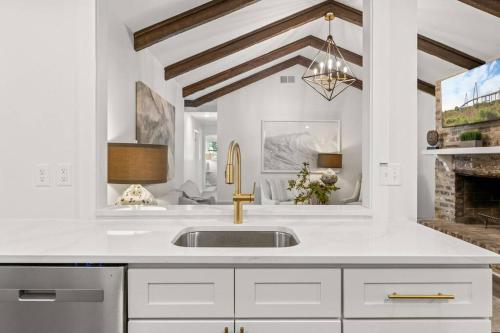 a white kitchen with a sink and a fireplace at The Gardenia House in Charleston