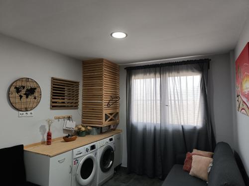 eine Waschküche mit einer Waschmaschine und einem Fenster in der Unterkunft Casa Glori in Vélez-Málaga