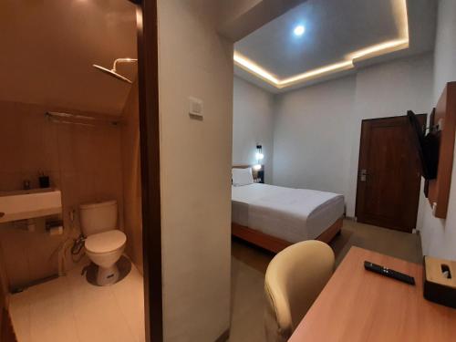 Habitación de hotel con cama y aseo en Griya Endika Syariah, en Yogyakarta