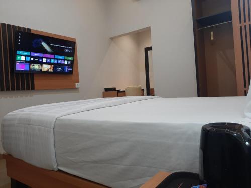 a bedroom with a large bed with a tv on the wall at Griya Endika Syariah in Yogyakarta