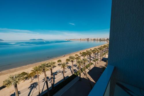 a view of a beach with palm trees and the ocean at DUKA Hotel in Vlorë