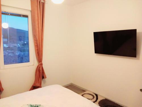 una camera con una TV su un muro con una finestra di Villa Marinov a Ohrid