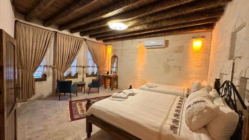 ein Schlafzimmer mit einem großen Bett in einem Zimmer mit Fenstern in der Unterkunft BABIL ANTIQUE HOTEL in Şanlıurfa