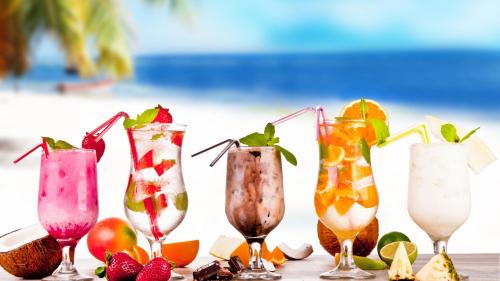 a group of four cocktails sitting on a table with fruit at Ô Bleu Azur in Antsatrakolo