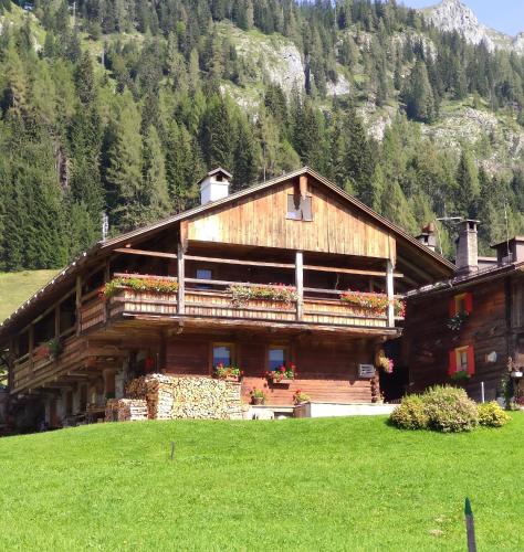 a large building with flowers on the side of it at Chalet - Margherita in Sappada