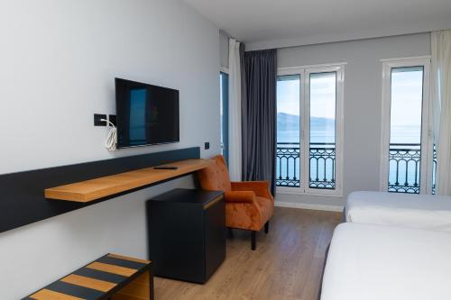 a hotel room with a desk and a balcony at DUKA Hotel in Vlorë