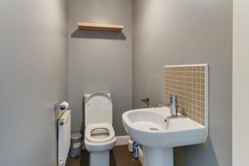 a small bathroom with a sink and a toilet at Charming 2-Bed House in Middleton Manchester in Manchester