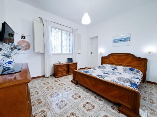 Un dormitorio con una cama y un escritorio y una ventana. en VILLA per vacanza relax Salento Puglia, en San Pietro in Bevagna