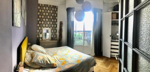 une petite chambre avec un lit et une fenêtre dans l'établissement Le beau Niçois, à Nice