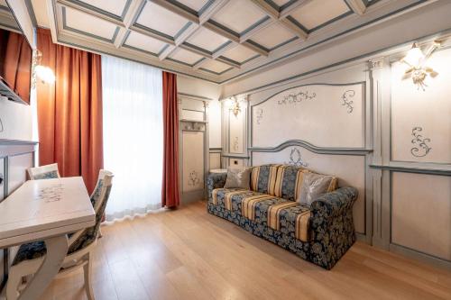 a living room with a couch and a table at Hotel Dolomiti Schloss in Canazei