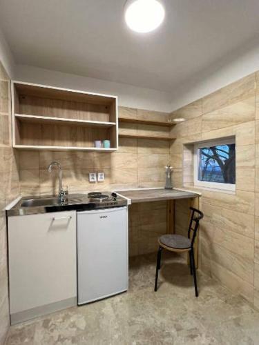 eine Küche mit einer Spüle und einer Theke mit einem Stuhl in der Unterkunft Apartman za odmor Varović in Križevci