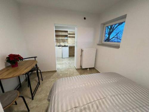 Schlafzimmer mit einem Bett, einem Tisch und einem Fenster in der Unterkunft Apartman za odmor Varović in Križevci