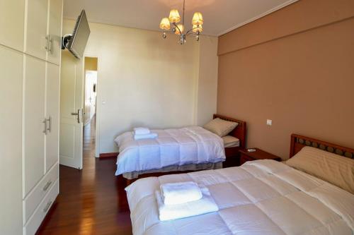 a bedroom with two beds and a chandelier at Place 2 Be in Nafpaktos