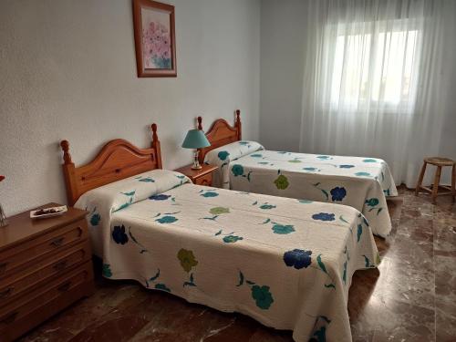 a bedroom with two beds and a dresser at LAS PALMERAS in Almuñécar