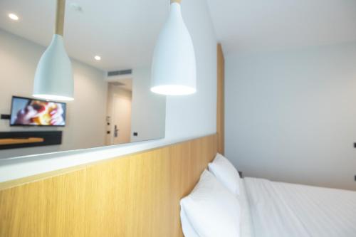 a bedroom with a bed with a mirror and a tv at DUKA Hotel in Vlorë