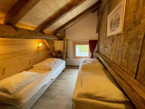 deux lits dans une chambre aux murs en bois dans l'établissement LA FERME DU FAY, à Sixt-Fer-à-Cheval