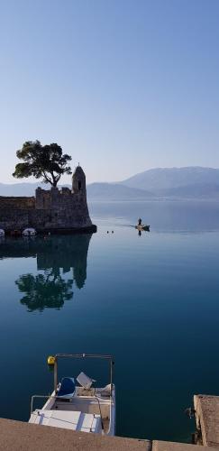 a boat sitting in the water next to a castle at Place 2 Be in Nafpaktos