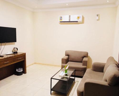 a living room with two couches and a tv at شقة الفخامة in Jeddah