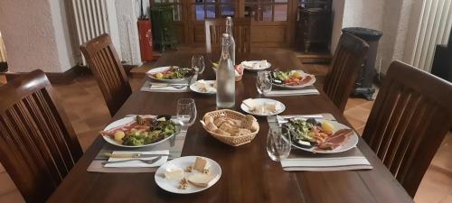 a table with plates of food and a bottle of wine at Les Vagabonds du Mont in Chichilianne