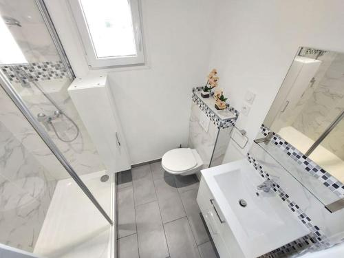 Un baño blanco con inodoro y lavabo. en Un havre de paix les pieds dans l'eau, en La Seyne-sur-Mer