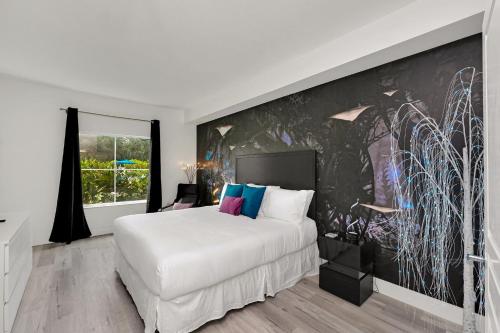 a bedroom with a white bed and a large wall at Your Pandora - minutes to parks in Orlando